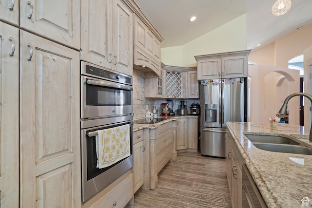 4925 W 3500 S, West Haven, UT 84401 - kitchen with appliances with stainless steel finishes, tasteful backsplash, light stone countertops, light wood finished floors, and arched walkways