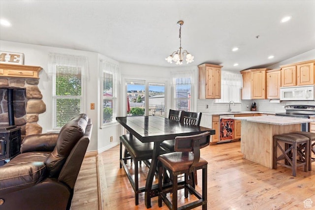 7217 W Mccuiston Ave S, Herriman, UT 84096 - dining room featuring a chandelier, light wood-style flooring, healthy amount of natural light, recessed lighting, and a wood stove