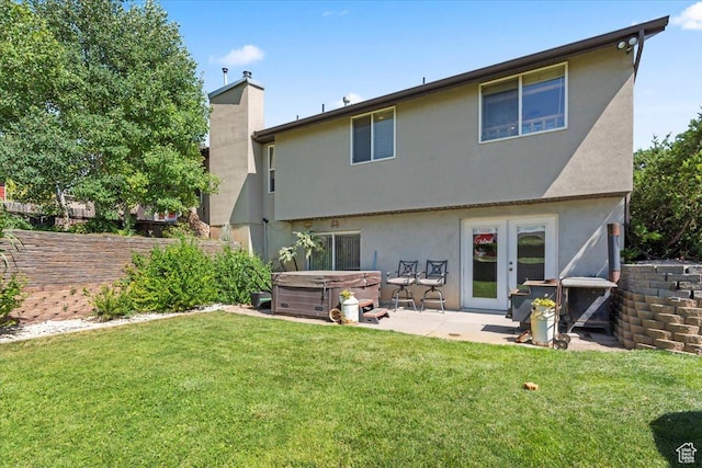 7217 W Mccuiston Ave S, Herriman, UT 84096 - back of property featuring a hot tub, french doors, a patio area, stucco siding, and a chimney