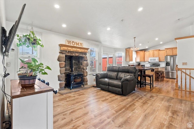 7217 W Mccuiston Ave S, Herriman, UT 84096 - living room featuring light wood finished floors, plenty of natural light, a wood stove, recessed lighting, and lofted ceiling