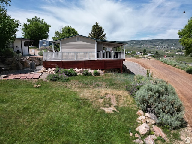 3077 S Edgemont Dr, Garden City, UT 84028 - back of property with a wooden deck and a yard