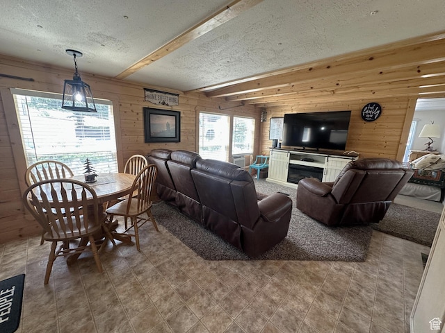 3077 S Edgemont Dr, Garden City, UT 84028 - living area featuring a textured ceiling, wooden walls, plenty of natural light, beamed ceiling, and tile patterned floors