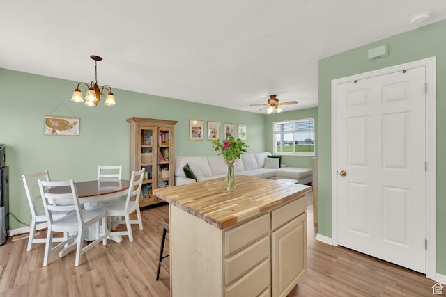 5318 S 4300 W, Hooper, UT 84315 - kitchen featuring wooden counters, light wood finished floors, a ceiling fan, pendant lighting, and a breakfast bar