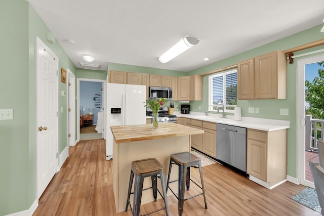 5318 S 4300 W, Hooper, UT 84315 - kitchen with stainless steel appliances, light brown cabinets, light wood-style flooring, and a kitchen breakfast bar