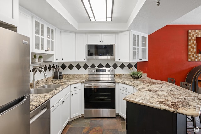 1035 Park Ave Unit 7-G, Park City, UT 84060 - kitchen with stainless steel appliances, a peninsula, backsplash, white cabinets, and light stone countertops