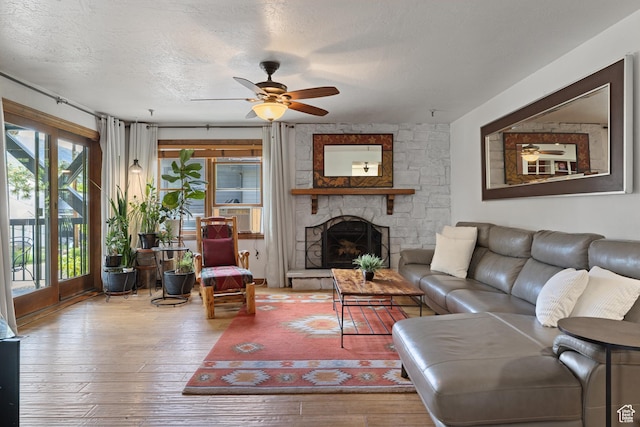 1035 Park Ave Unit 7-G, Park City, UT 84060 - living room featuring ceiling fan, hardwood / wood-style flooring, a stone fireplace, and a textured ceiling