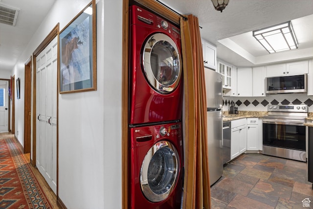1035 Park Ave Unit 7-G, Park City, UT 84060 - washroom with stacked washing machine and dryer and dark stone finish flooring