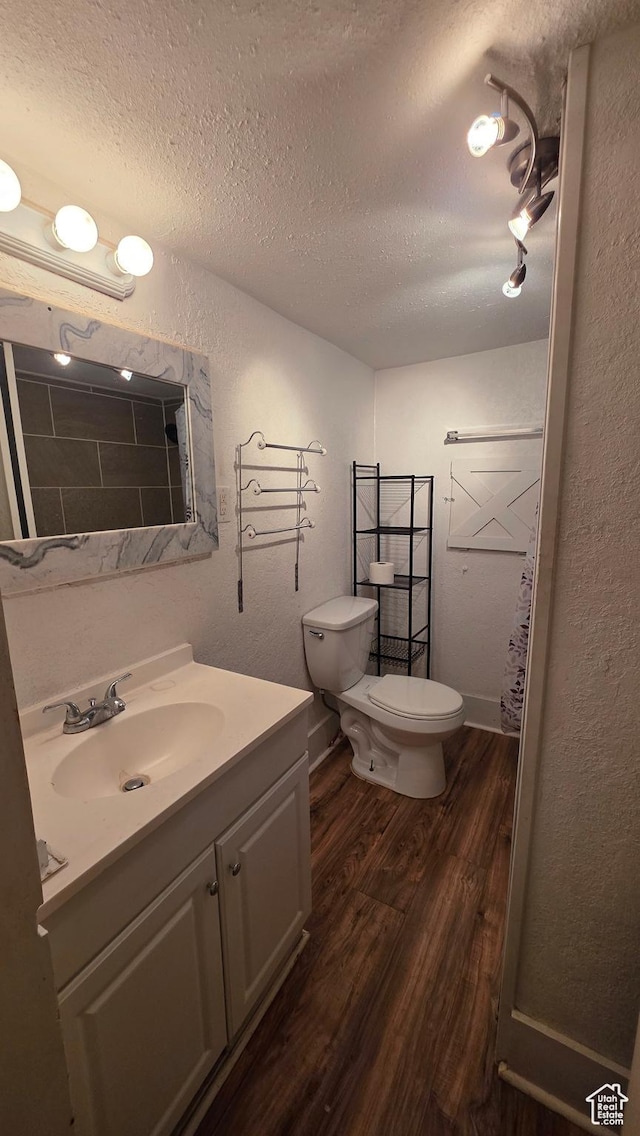 358 E 11th St, Ogden, UT 84404 - bathroom featuring wood finished floors, a textured ceiling, a textured wall, and vanity