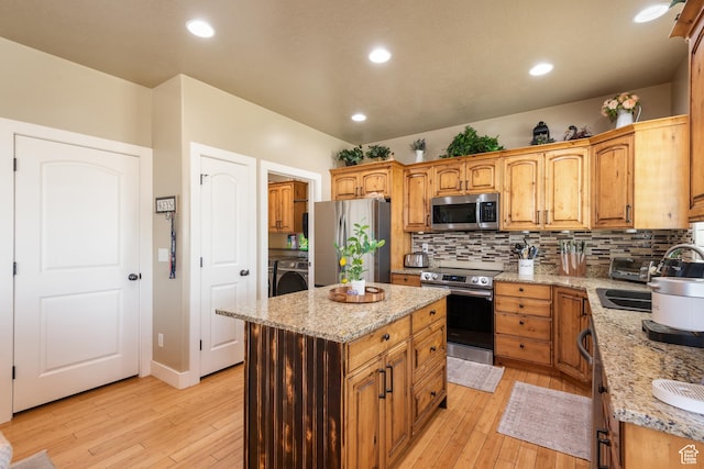 3535 W Overlook Dr, Layton, UT 84041 - kitchen featuring appliances with stainless steel finishes, washer / clothes dryer, decorative backsplash, light wood finished floors, and recessed lighting