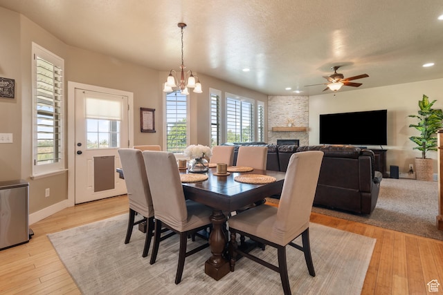 3535 W Overlook Dr, Layton, UT 84041 - dining space with light wood finished floors, a chandelier, recessed lighting, a ceiling fan, and a fireplace