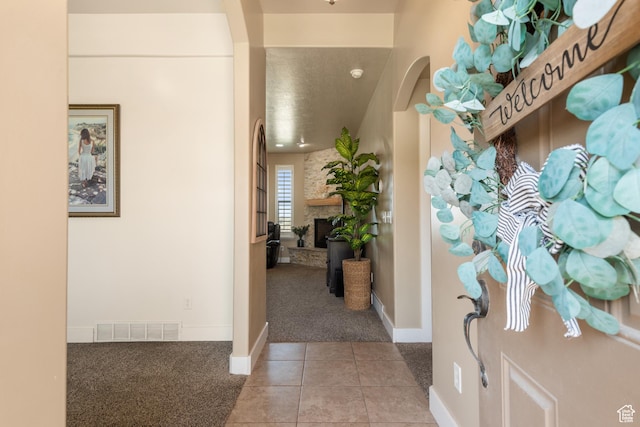 3535 W Overlook Dr, Layton, UT 84041 - foyer entrance with light colored carpet, light tile patterned floors, arched walkways, and a fireplace