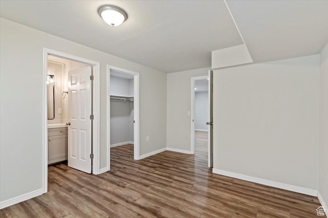 9714 S Oia Ln W, South Jordan, UT 84095 - unfurnished bedroom featuring wood finished floors, a closet, connected bathroom, and a walk in closet