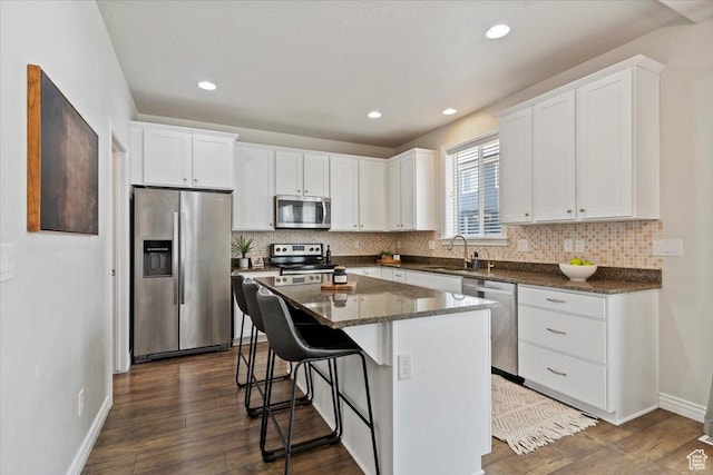 9714 S Oia Ln W, South Jordan, UT 84095 - kitchen featuring stainless steel appliances, a kitchen breakfast bar, white cabinets, a center island, and tasteful backsplash