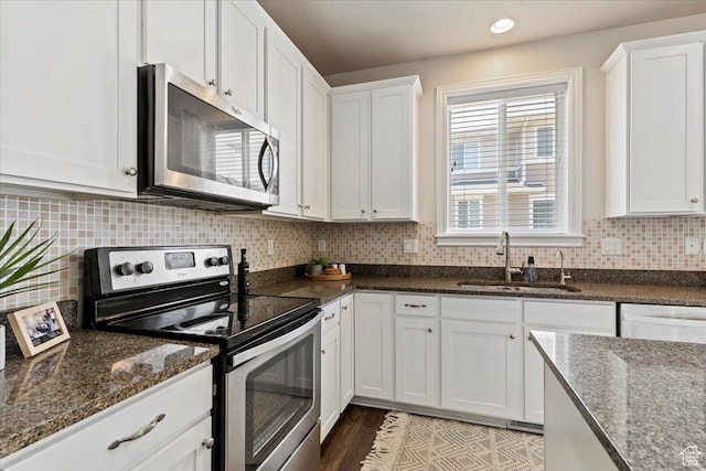 9714 S Oia Ln W, South Jordan, UT 84095 - kitchen with appliances with stainless steel finishes, white cabinets, dark stone countertops, tasteful backsplash, and recessed lighting