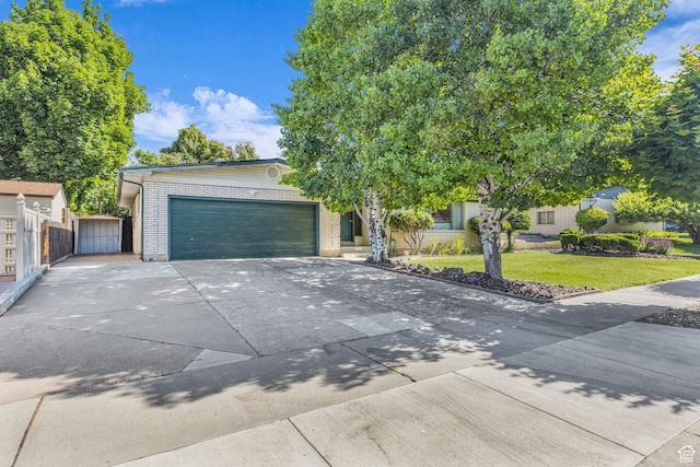 1731 E 1460 N, Logan, UT 84341 - obstructed view of property with an attached garage, concrete driveway, brick siding, and a gate