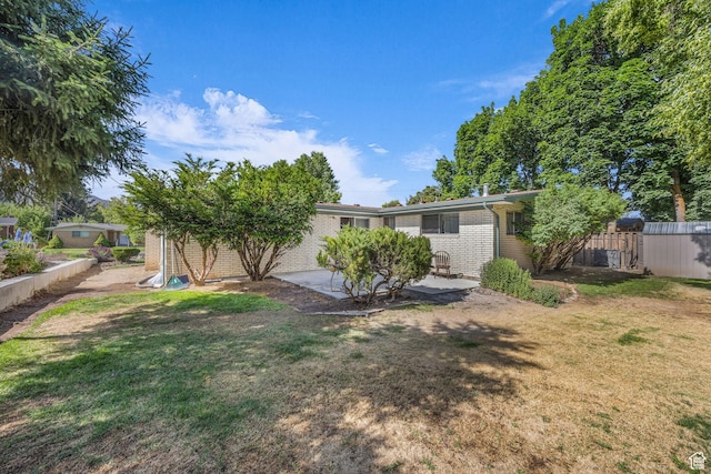 1731 E 1460 N, Logan, UT 84341 - rear view of house featuring brick siding, a lawn, and a patio