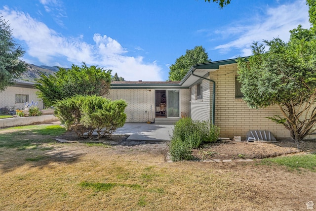 1731 E 1460 N, Logan, UT 84341 - rear view of property featuring a lawn, a patio, and brick siding