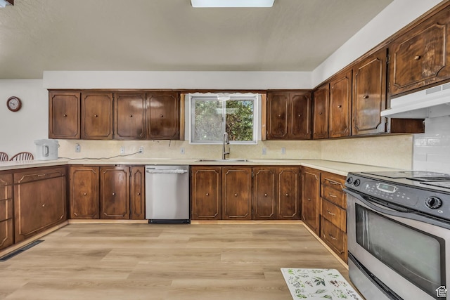 1731 E 1460 N, Logan, UT 84341 - kitchen featuring stainless steel appliances, light countertops, light wood-style floors, backsplash, and under cabinet range hood