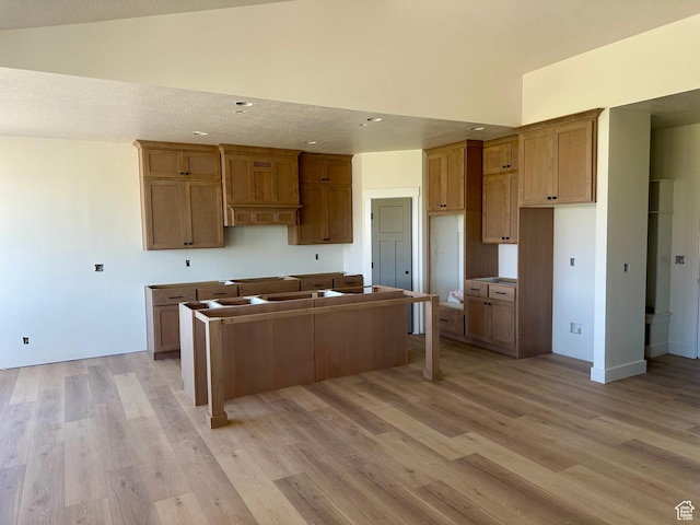 1885 N 4475 W, Plain City, UT 84404 - kitchen featuring a kitchen island, light wood-type flooring, vaulted ceiling, recessed lighting, and brown cabinetry