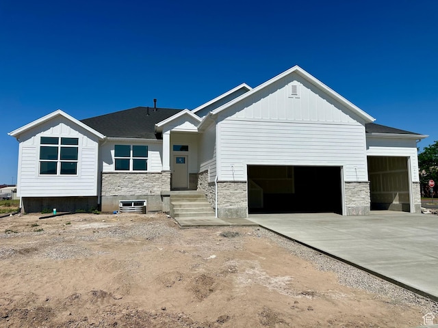 1885 N 4475 W, Plain City, UT 84404 - view of front of property featuring an attached garage, stone siding, board and batten siding, and concrete driveway