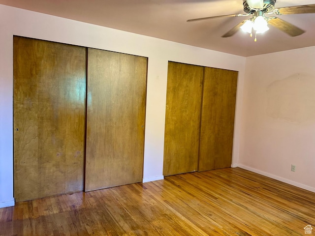 372 E 800 N, Logan, UT 84321 - unfurnished bedroom with hardwood / wood-style flooring, multiple closets, and a ceiling fan