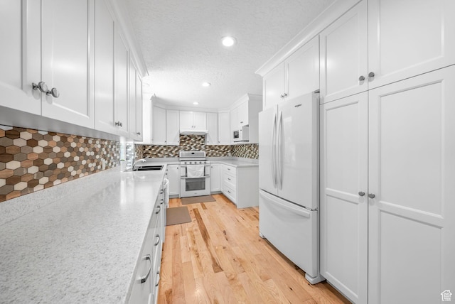 1700 N Bluebird Rd, Orem, UT 84097 - kitchen featuring white appliances, light wood-style floors, white cabinets, backsplash, and a textured ceiling