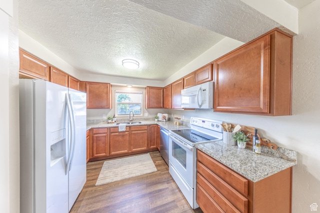 774 W 4375 S, Riverdale, UT 84405 - kitchen featuring white appliances, dark wood-style flooring, brown cabinetry, and a textured ceiling