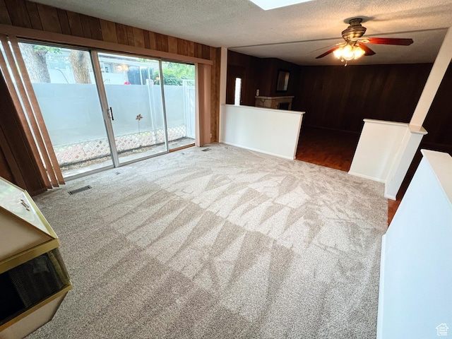 399 W 400 N Unit 47, Bountiful, UT 84010 - unfurnished living room featuring wooden walls, carpet, a textured ceiling, and a ceiling fan