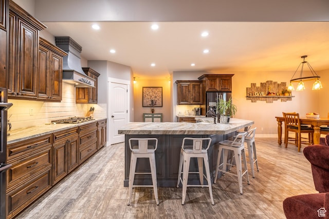 4311 N Diamond Ln, Erda, UT 84074 - kitchen with stainless steel appliances, light countertops, premium range hood, backsplash, and a breakfast bar