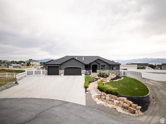 4311 N Diamond Ln, Erda, UT 84074 - view of front of house featuring an attached garage, driveway, stone siding, a mountain view, and stucco siding