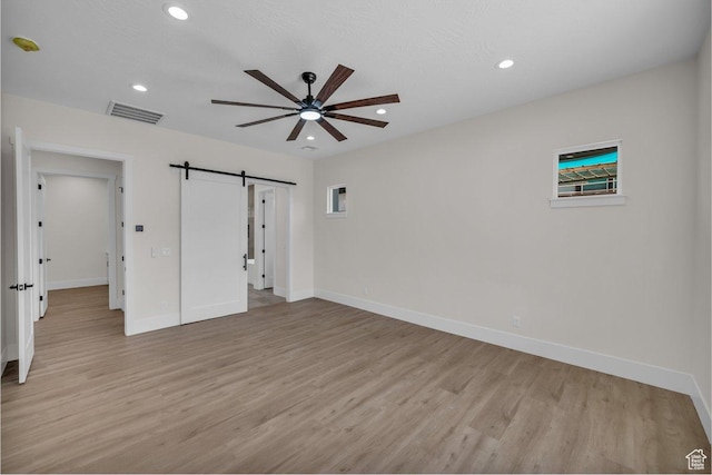 21 W Elinor Ln, Washington, UT 84780 - unfurnished bedroom with a barn door, light wood-style flooring, recessed lighting, and a ceiling fan