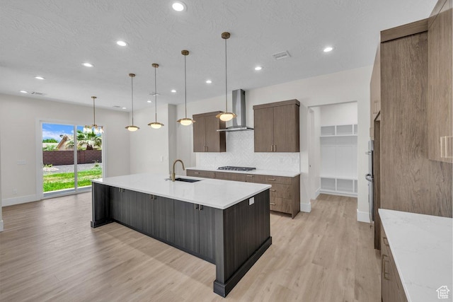 21 W Elinor Ln, Washington, UT 84780 - kitchen with wall chimney exhaust hood, light wood-style flooring, decorative backsplash, recessed lighting, and a spacious island