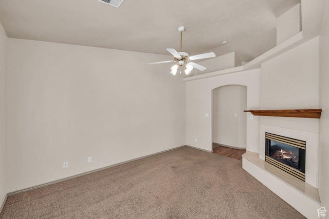 579 E Spring Cir, Washington, UT 84780 - unfurnished living room featuring carpet, ceiling fan, arched walkways, and a glass covered fireplace