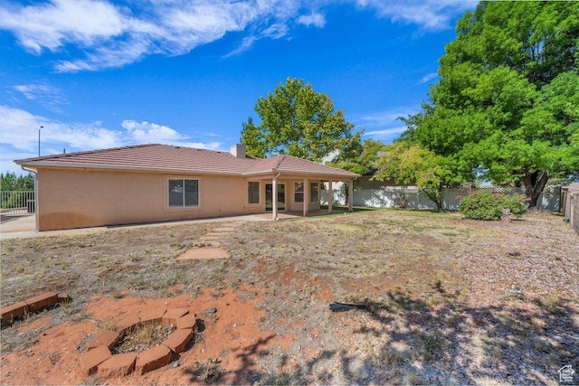 579 E Spring Cir, Washington, UT 84780 - rear view of house with a fenced backyard, a patio area, a chimney, a tile roof, and stucco siding