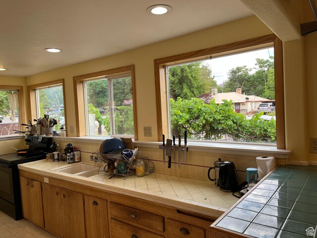 102 N 300 E, Moab, UT 84532 - kitchen with black electric range, healthy amount of natural light, tile counters, and recessed lighting