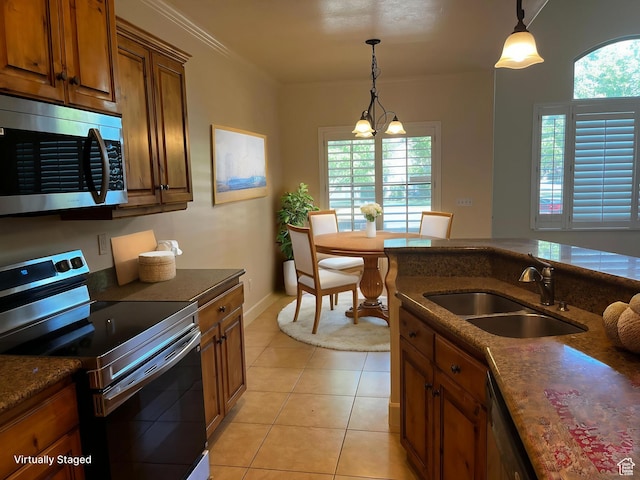 933 N 900 W, Orem, UT 84057 - kitchen featuring stainless steel appliances, brown cabinets, dark stone countertops, light tile patterned flooring, and hanging light fixtures