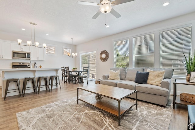 1304 E Weyburn Ln S Unit 10, Holladay, UT 84117 - living room with light wood-style floors, recessed lighting, a ceiling fan, a textured ceiling, and a chandelier