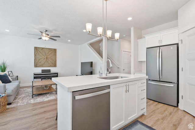 1304 E Weyburn Ln S Unit 10, Holladay, UT 84117 - kitchen featuring appliances with stainless steel finishes, open floor plan, light countertops, recessed lighting, and a textured ceiling