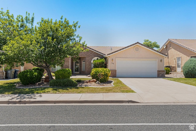 187 N Westridge Dr Unit 155, St George, UT 84770 - view of front of property featuring an attached garage, a tiled roof, concrete driveway, stucco siding, and brick siding