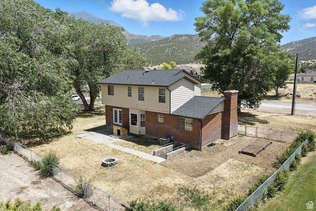 585 N 700 E, Nephi, UT 84648 - rear view of property with a mountain view, brick siding, a chimney, and roof with shingles