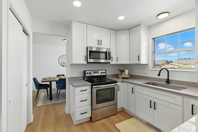585 N 700 E, Nephi, UT 84648 - kitchen with stainless steel appliances, light countertops, white cabinets, light wood-type flooring, and recessed lighting