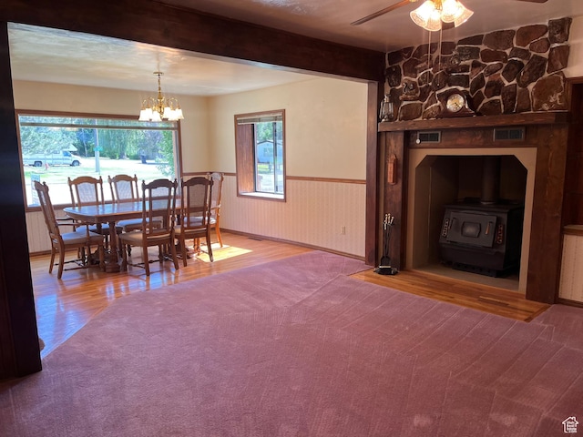 294 W 200 N, Mount Pleasant, UT 84647 - dining area featuring a wood stove, wood finished floors, ceiling fan, wainscoting, and a chandelier