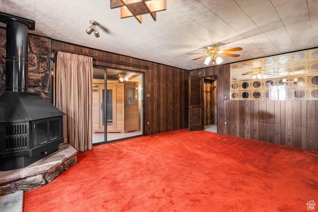 294 W 200 N, Mount Pleasant, UT 84647 - unfurnished living room with a wood stove, carpet flooring, wood walls, and ceiling fan