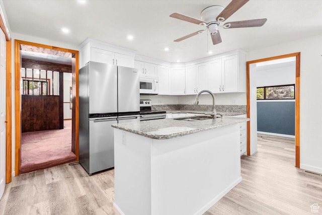 294 W 200 N, Mount Pleasant, UT 84647 - kitchen featuring appliances with stainless steel finishes, light wood-style floors, white cabinetry, light stone countertops, and recessed lighting