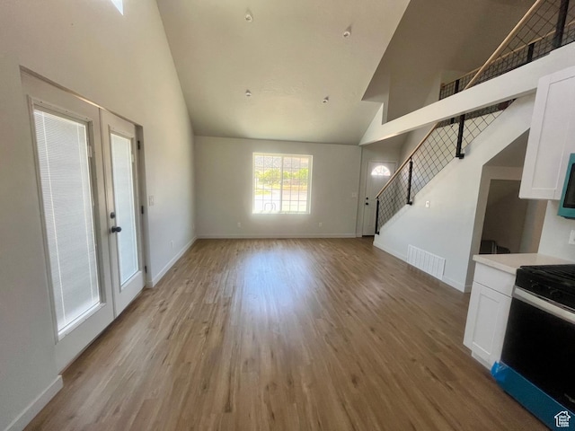 599 N State St, Mayfield, UT 84643 - unfurnished living room with high vaulted ceiling, light wood-style flooring, and stairs