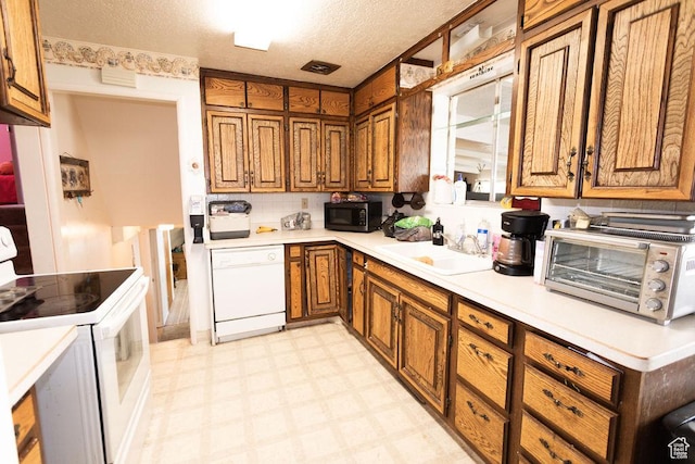 960 N 100 W, Tremonton, UT 84337 - kitchen featuring white appliances, brown cabinetry, light flooring, light countertops, and a textured ceiling