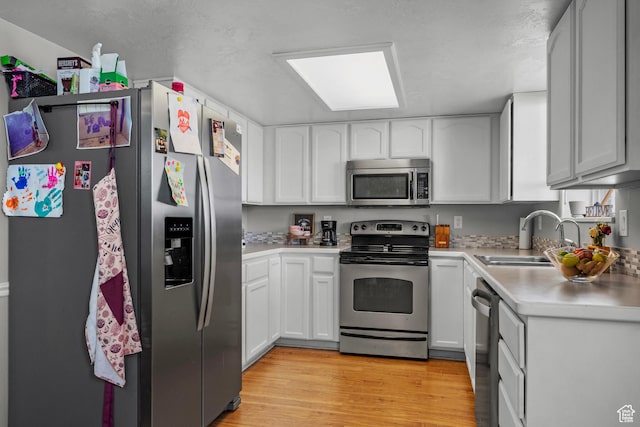 70 E 135 N, Orem, UT 84057 - kitchen with appliances with stainless steel finishes, light countertops, light wood-style flooring, and white cabinets