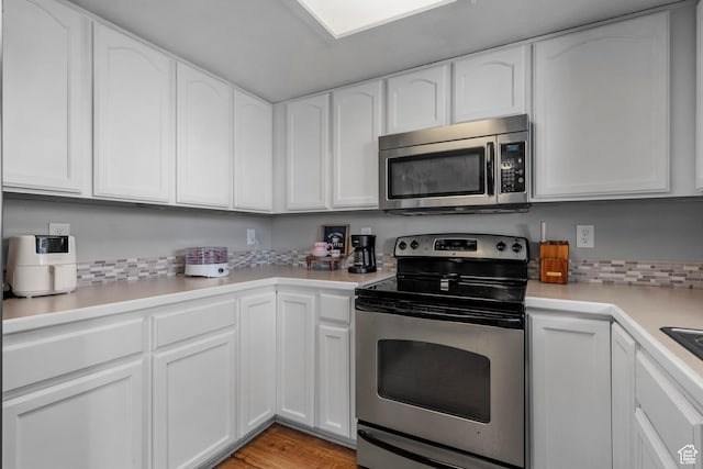 70 E 135 N, Orem, UT 84057 - kitchen featuring stainless steel appliances, white cabinets, light countertops, light wood-style floors, and tasteful backsplash