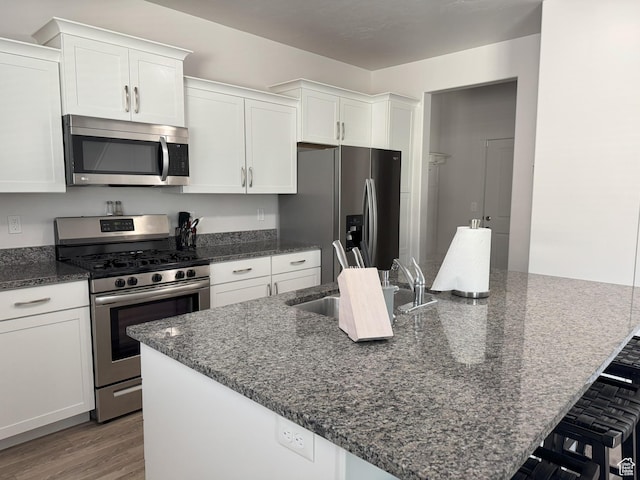 1637 S 730 W, Provo, UT 84601 - kitchen with appliances with stainless steel finishes, white cabinets, a spacious island, and light wood-style flooring