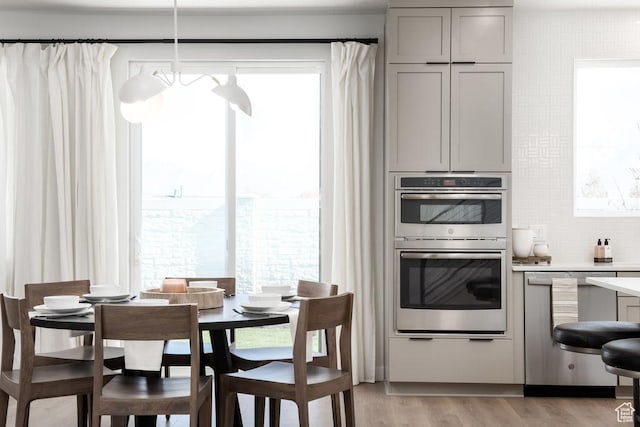 8072 S 300 E Unit 246, Midvale, UT 84070 - kitchen featuring stainless steel appliances, gray cabinets, light countertops, light wood-style flooring, and decorative backsplash